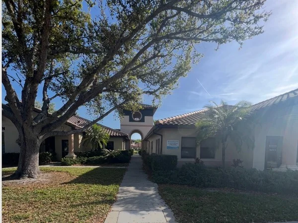 Sunshine Rheumatology Venice office building with walkway and palm trees
